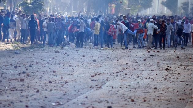 Protesters hurl stones during violent clashes between anti- and pro-CAA demonstrations, at Jaffarabad in New Delhi on Monday.(Raj K Raj/HT Photo)