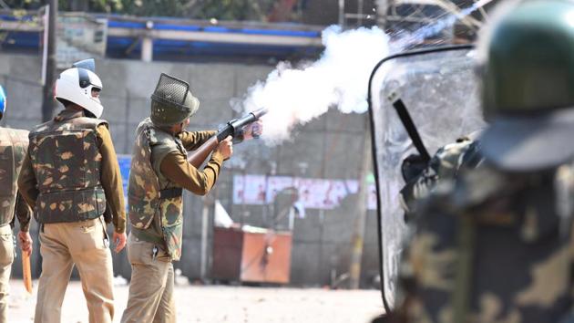 Police personnel fire tear gas during violent clashes between anti and pro CAA demonstrations, at Jaffarabad, near Maujpur, in New Delhi.(Raj K Raj/HT PHOTO)