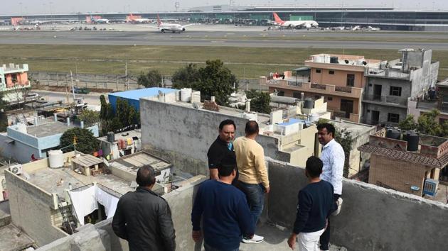 Residents on a rooftop at Shahbad Mohammadpur village, near Dwarka, in New Delhi. Vipin Lamba looks pretty dismayed as he refers to his village, Shahabad Mohammadpur, in south-west Delhi, as a “unique transport hub”. “You can see and hear planes take off and land in our vicinity all the time, a Metro passes underground, and trains rattle through our village throughout the day,” he says. “But these modes of transport have only been a source of trouble.” (Vipin Kumar / HT Photo)