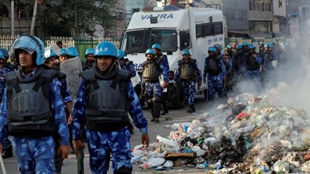 Members of Rapid Action Force (RAF) move past smoldering debris after it was set on fire by demonstrators in a riot affected area after fresh clashes erupted between people demonstrating for and against a new citizenship law in New Delhi, India, February 25, 2020.(REUTERS)