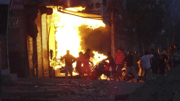 A shop burns as a mob sets it on fire during violence between two groups in New Delhi. Delhi Police spokesperson Mandeep Randhawa said 11 first information reports have been registered and 20-25 persons have been detained in connection with the violence. (AP)