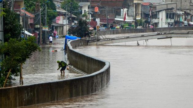 A man walks through a flooded road after heavy rain in Jakarta. According to report by Reuters that police warned of road closures and disruption to trains. (BAY ISMOYO / AFP)