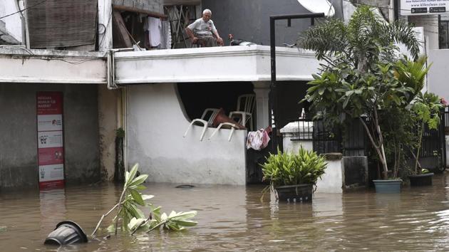 An elderly man sits on the second floor of his home in a flooded neighbourhood in Jakarta.Indonesia’s weather agency linked the rains to tropical cyclones that brought bad weather to southern parts of the archipelago. It also warned of high waves in the seas south of Java island. (Tatan Syuflana / AP)