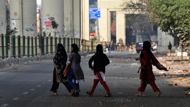 Women cross a road at the site of clashes between pro and anti-CAA groups on the road connecting Maujpur and Jafrabad. Late at night, women protesters at Jafrabad announced “temporarily” shifting their anti-CAA stir to Seelampur to ensure their “safety and security” in the wake of the clashes. “We will restore the sit-in once the situation is under control,” said a protester, requesting anonymity. (Biplov Bhuyan / HT Photo)