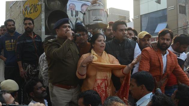 A police personnel addresses the crowd in the presence of BJP leader Kapil Mishra, at Maujpur, in New Delhi.(Sonu Mehta/HT PHOTO)