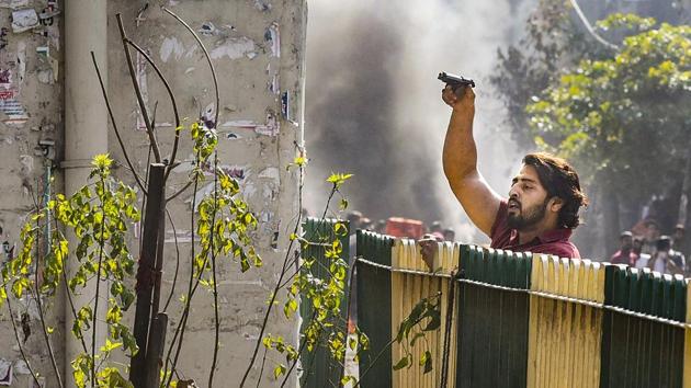 A protestor brandishes a pistol during clashes between a group of anti-CAA protestors and supporters of the new citizenship act, at Jafrabad in north-east Delhi.(PTI)