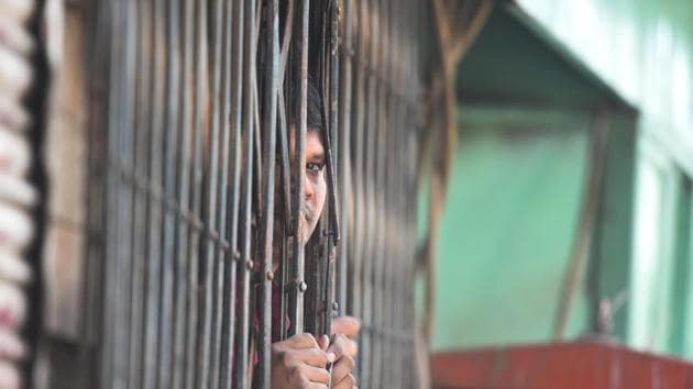 A man looks out from a building at the site of clashes between pro and anti-CAA groups on the road connecting Maujpur and Jafrabad. The 1.2km stretch from Jafrabad to Maujpur remained tumultuous just as it was on Monday, but clashes were reported from areas such as Bhajanpura, Kardampuri, Shastri Park, Brahmpuri and Jyoti Nagar, which were largely unaffected a day ago. Rioters damaged two fire tenders in Gokalpuri, and crowds shouting incendiary slogans set on fire a bike in Maujpur. (Raj K Raj / HT Photo)