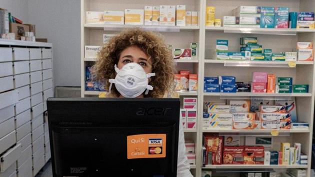 A chemist wears a protective mask as she waits for customers in a pharmacy. Her husband and children live in nearby Brescia but she decided to stay in the red zone to keep the pharmacy open. The town mayor found an apartment for her so she didn’t have to pay rent. (Marzio Toniolo / REUTERS)