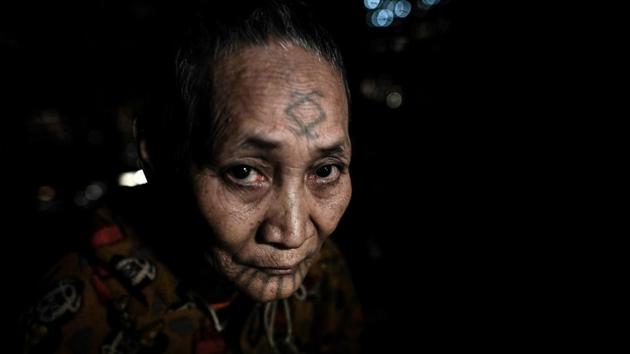 Khamyo Pon Nyun, Ngon Pok’s wife, said she chose to have geometric designs etched on her arms, legs and face as a teenager. “It was so painful,” Nyun, who is aged 75, remembered. “But I told myself if my mum and my aunts could do it then so could I,” she said, adding with a smile that—unlike her husband—she did not need to be restrained to withstand the pain. The tattoos can signify tribal identity, life accomplishments or the completion of a rite of passage. (Ye Aung Thu / AFP)