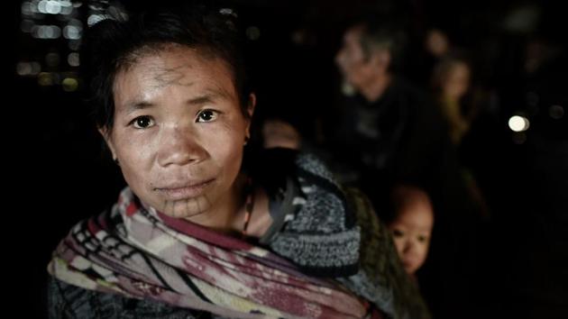Ku Myo, 35, a tattooed Lainong tribeswoman, carries her child in their house at Lahel township in Sagaing region of Myanmar. She said her parents were less than impressed after she came home aged 15 with her face tattooed. “I did it without them knowing and they beat me when they found out,” she said, admitting she too would be furious if her children exhibited the same rebellious streak. (Ye Aung Thu / AFP)