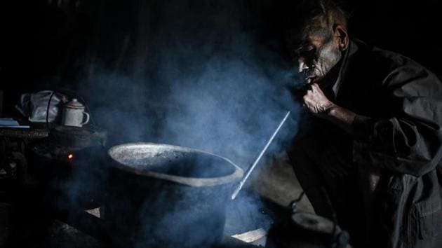 Nok Tan, 75, a tattooed Konyak tribeman, cooks in his house in a village in Sagaing. The Naga consist of dozens of tribes in a region so isolated that neighbouring villages often speak completely different languages and dialects. Divided between India and Myanmar by a border many deem as artificial, today a proud sense of nationalism unites the disparate tribes. (Ye Aung Thu / AFP)