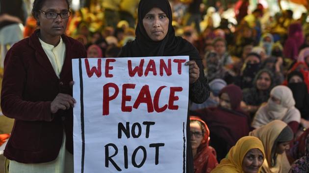 Women hold a placard during the ongoing sit-in protest against NPR, NRC and CAA in Shaheen Bagh.(Burhaan Kinu/HT PHOTO)