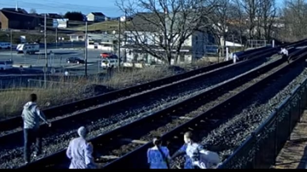 Image shows the members of the family rushing off the tracks.(YouTube/Virtual Railfan)