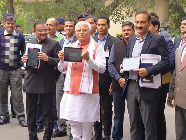 Haryana chief minister Manohar Lal Khattar before presenting the budget estimates on a tablet device in Chandigarh on Friday. Legislators accessed the budget online.(Keshav Singh/HT)