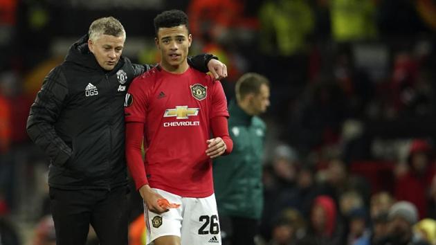 Manchester United's manager Ole Gunnar Solskjaer, left, and Manchester United's Mason Greenwood walk on the pitch.(AP)