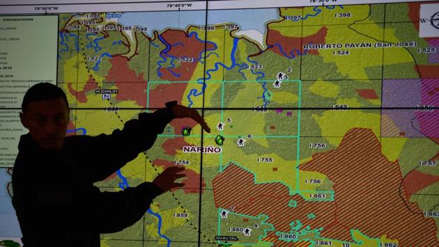 A Colombian police officers shows a map with coca growing areas in Tumaco. “The police are not going to withdraw from the national parks where the criminals are trying to settle,” Carlos Holmes Trujillo told reporters of AFP in Bogota. “We are going to harden the military offensive to remove them from their dens.” (Raul Arboleda / AFP)