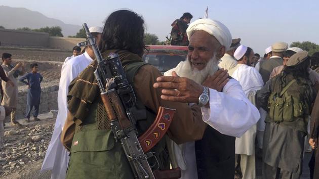 In this file photo, Taliban fighters gather with residents to celebrate a 3-day cease fire marking the holiday of Eid al-Fitr, in Nangarhar, east of Kabul. Many Afghans view the expected signing of a U.S.-Taliban peace deal with a heavy dose of skepticism.(AP)