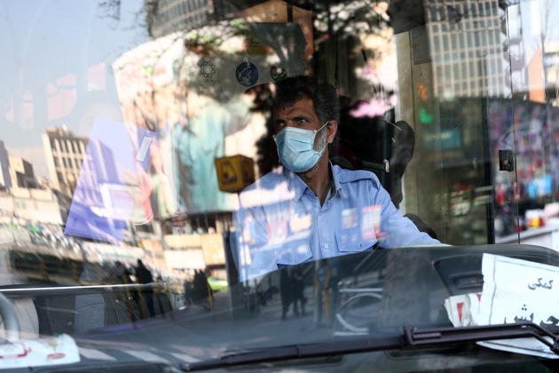 A bus driver wearing a protective a mask, to prevent contracting coronavirus, drives a bus in Tehran, Iran. The virus and the COVID-19 illness it causes have killed 43 people out of 593 confirmed cases in Iran, Health Ministry spokesman Kianoush Jahanpour said. The country is preparing for the possibility of “tens of thousands” of people getting tested for the new coronavirus as the number of confirmed cases spiked again Saturday. (Nazanin Tabatabaee via REUTERS)
