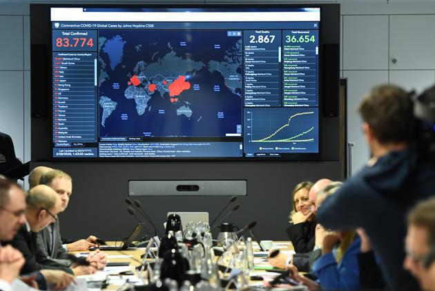 A display shows the latest information on the spread of the novel coronavirus worldwide during a crisis meeting of government officials in Berlin, Germany. At the Cologne Cathedral in Germany, basins of holy water were emptied for fear of spreading germs. The country has registered 57 cases of the virus. (Annegret Hilse / REUTERS)