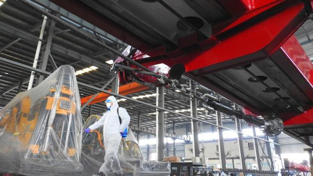 A worker in protective suit disinfects a factory before it resumes operation.(REUTERS)