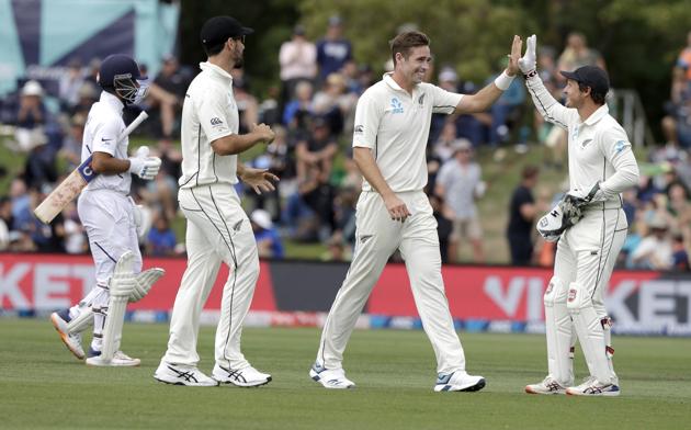 New Zealand's Tim Southee, second right, is congratulated by teammate BJ Watling, right, after dismissing India's Ajinkya Rahane, left, for seven runs during play on day one of the second cricket test between New Zealand and India at Hagley Oval in Christchurch. (AP)