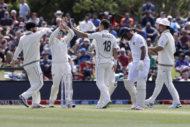 New Zealand's Trent Boult, centre, is congratulated by teammates after taking the wicket of India's Mayank Agarwal, second right, during play on day one of the second cricket test between New Zealand and India at Hagley Oval in Christchurch. (AP)