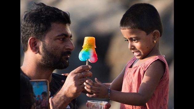 A man offers an ice gola to a child to deal with heat during a hot day at Versova in Mumbai, Maharashtra. (Satyabrata Tripathy / HT Photo) A man offers an ice gola to a child to deal with heat during a hot day at Versova in Mumbai, Maharashtra. (Satyabrata Tripathy / HT Photo)