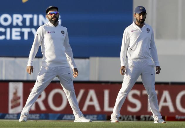 India's Virat Kohli, left, stands with teammate Cheteshwar Pujara during play on day one of the second cricket test between New Zealand and India at Hagley Oval in Christchurch. (AP)