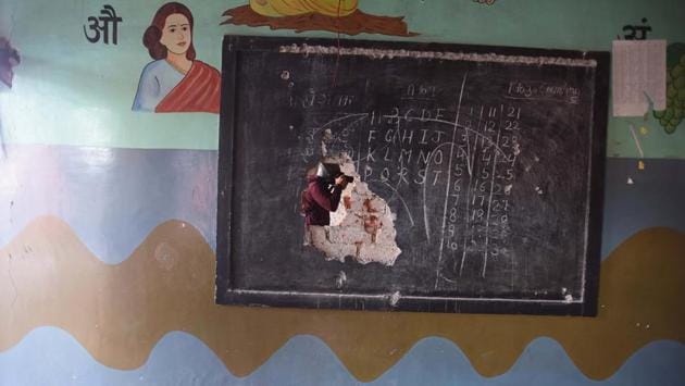 A photographer is seen through a damaged black board following violent clashes over the new citizenship law at Shiv Vihar in New Delhi. (Raj K Raj / HT Photo) A photographer is seen through a damaged black board following violent clashes over the new citizenship law at Shiv Vihar in New Delhi. (Raj K Raj / HT Photo)