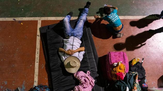 A man and a child displaced from a rural area due to conflicts between illegal groups, rest at a gymnasium where they are taking shelter in Ituango, Antioquia department, Colombia. Hundreds of people had to leave their homes in northwest Colombia after being threatened by armed groups disputing the control of drug plantations. (Pablo Cuellar / AFP)