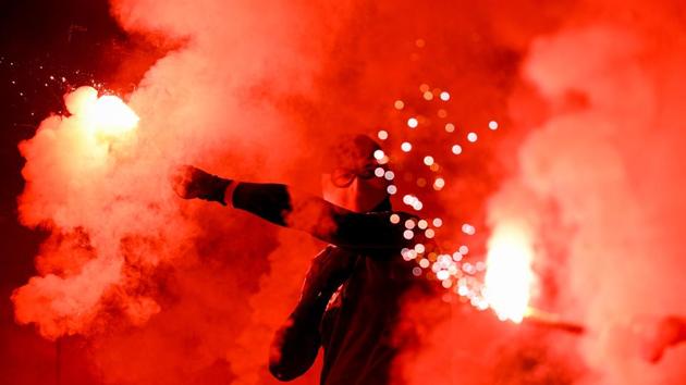 A Wolfsburg's supporter lights flares during the UEFA Europa League Last 32 Second Leg football match between Malmo aand Wolfsburg in Malmo, Sweden. (Jonathan Nackstrand / AFP)
