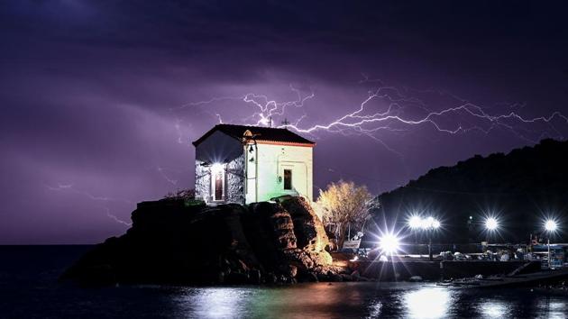 Lightning strikes behind the chapel of Panagia Gorgona in the village of Skala Sykamias, north of Lesbos, Greece. (Aris Messinis / AFP)