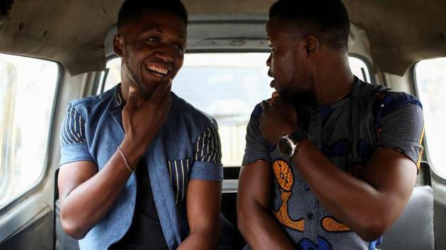 Chris Agiriga is seen in a minibus with a friend in Lagos. After the raids, Agiriga’s aunt took him to her church and arranged for her pastor to house him on the premises. Agiriga slept on the floor of an outhouse that he shared with another homeless man who had been taken in by the church. (Temilade Adelaja / REUTERS) 