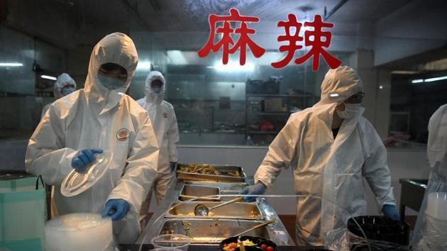 Cooks wearing hazardous material suits prepare lunch for workers at a garment factory. Wenzhou is one of the hardest-hit areas, with 504 cases and one death as of Friday, compared with 337 infections in far larger Shanghai. Along with other cities in Zhejiang province, Wenzhou adopted harsh restrictions on residents’ movements on February 2. Ugly Duck was asked by local authorities to do its part. (Noel Celis / AFP) Cooks wearing hazardous material suits prepare lunch for workers at a garment factory. Wenzhou is one of the hardest-hit areas, with 504 cases and one death as of Friday, compared with 337 infections in far larger Shanghai. Along with other cities in Zhejiang province, Wenzhou adopted harsh restrictions on residents’ movements on February 2. Ugly Duck was asked by local authorities to do its part. (Noel Celis / AFP)