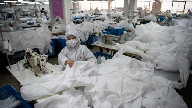 One workshop nearly the size of a football pitch, the bright-white polypropylene material is first cut into basic shapes, then stitched together in stages, and finally folded and packaged on an assembly line by workers who are also clad in the head-to-toe suits to prevent contamination. (Noel Celis / AFP) One workshop nearly the size of a football pitch, the bright-white polypropylene material is first cut into basic shapes, then stitched together in stages, and finally folded and packaged on an assembly line by workers who are also clad in the head-to-toe suits to prevent contamination. (Noel Celis / AFP)