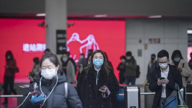 Passengers wearing protective masks pass through fare gates at a subway station in Shanghai, China, on Monday, March 2, 2020.(Bloomberg)