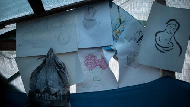 Drawings are stuck up inside a temporary shelter. Hosini built a shelter in an olive grove next to the official Moria camp. The grove itself has become a tent city after Moria overflowed. (Alkis Konstantinidis / REUTERS) Drawings are stuck up inside a temporary shelter. Hosini built a shelter in an olive grove next to the official Moria camp. The grove itself has become a tent city after Moria overflowed. (Alkis Konstantinidis / REUTERS)