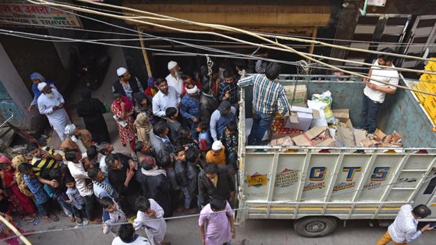 People gather to receive food supplies at Indra Vihar area in Mustafabad on March 1. (Sanchit Khanna / HT Photo)
