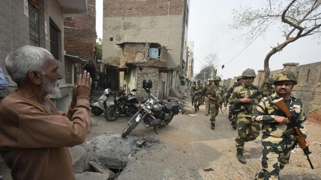 A man gestures at police and paramilitary personnel during a flag march following the violent clashes at Karawal Nagar on February 26. The Ghaziabad district administration on Tuesday completely sealed three routes at Lal Bagh, DLF Pushta and near Loni town, near Karawal Nagar. Liquor shops were also shut for a day. (Biplov Bhuyan / HT Photo)