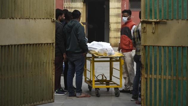 Relatives wait to collect the body of a deceased person who was killed in the violence outside GTB hospital mortuary, on February 27. (Biplov Bhuyan / HT Photo)
