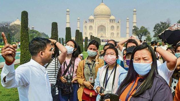 Tourists tour Taj Mahal wearing masks. (PTI) Tourists tour Taj Mahal wearing masks. (PTI)