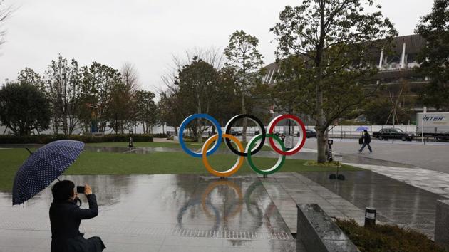 Tokyo: A woman takes pictures of the Olympic rings near the New National Stadium in Tokyo. (AP) Tokyo: A woman takes pictures of the Olympic rings near the New National Stadium in Tokyo. (AP)