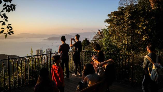 People seen taking photographs at a lookout point along a hiking trail in Hong Kong. Hong Kongers are escaping the coronavirus anxiety that has gripped the crowded city by heading for the hills to find fresh air and space to exercise. (Vivek Prakash / AFP) People seen taking photographs at a lookout point along a hiking trail in Hong Kong. Hong Kongers are escaping the coronavirus anxiety that has gripped the crowded city by heading for the hills to find fresh air and space to exercise. (Vivek Prakash / AFP)