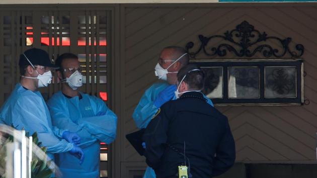 Medics in disposable gowns and masks talk outside the Life Care Center of Kirkland, a long-term care facility linked to several confirmed coronavirus cases, in Kirkland, Washington on March 4.(Reuters Photo) Medics in disposable gowns and masks talk outside the Life Care Center of Kirkland, a long-term care facility linked to several confirmed coronavirus cases, in Kirkland, Washington on March 4.(Reuters Photo)