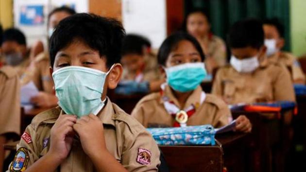 Students wear protective masks in school (REUTERS)