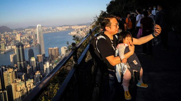 A man takes a selfie with his baby along a hiking trail. While the financial hub is known for soaring skyscrapers and cramped housing blocks, its steep mountains and remote hiking trails offer welcome relief from the Covid-19 fears which triggered the closure of public facilities. (Vivek Prakash / AFP) A man takes a selfie with his baby along a hiking trail. While the financial hub is known for soaring skyscrapers and cramped housing blocks, its steep mountains and remote hiking trails offer welcome relief from the Covid-19 fears which triggered the closure of public facilities. (Vivek Prakash / AFP)