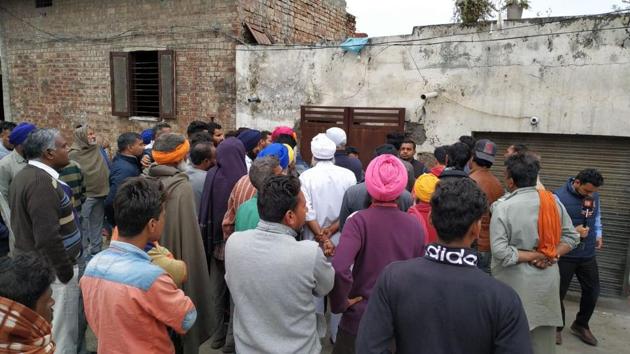 Residents of Moole Chak village of Amritsar gather outside the house whose roof collapsed after rain on Friday morning.(Sameer Sehgal/HT)