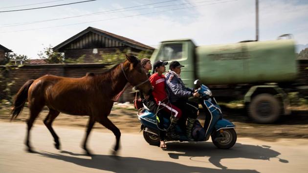 Captain Khundongbam Habe, rides a scooter with teammates Khundongbam Dementy and Shanglenmayum Sangeeta as they lead a pony back to Thangmeiband Polo Ground.” The game dates back centuries in Manipur, where it first came to the attention of British colonialists who formalised it as polo and spread it around the world. (Xavier Galiana / AFP) Captain Khundongbam Habe, rides a scooter with teammates Khundongbam Dementy and Shanglenmayum Sangeeta as they lead a pony back to Thangmeiband Polo Ground.” The game dates back centuries in Manipur, where it first came to the attention of British colonialists who formalised it as polo and spread it around the world. (Xavier Galiana / AFP)