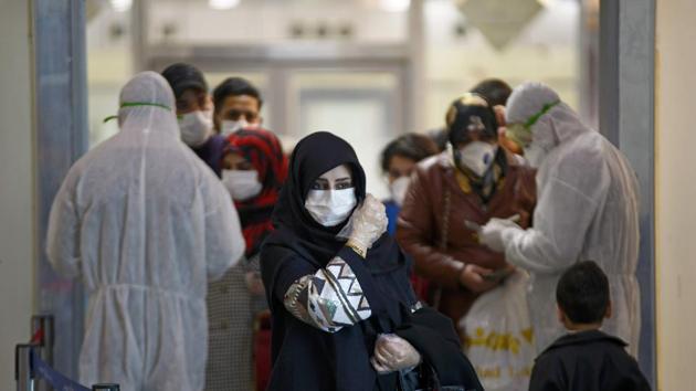 Medical staff in protective gears distribute information sheets to Iraqi passengers returning from Iran at Najaf International Airport on March 5, 2020. (Photo: AFP) Medical staff in protective gears distribute information sheets to Iraqi passengers returning from Iran at Najaf International Airport on March 5, 2020. (Photo: AFP)