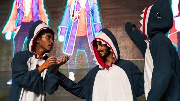 Emiratis Hamad al-Shamsi, left, Rashid al-Qubaisi, center, and Abdullah al-Shamsi, right, prepare for a dance-off as Hamad al-Shamsi applies hand sanitizer at the Middle East Film & Comic Con in Dubai, United Arab Emirates, Thursday, March 5, 2020. The Middle East Film & Comic Con began Thursday night in Dubai, a city of skyscrapers and nightclubs suddenly subdued by the outbreak of the new coronavirus across the region. (AP Photo/Jon Gambrell) (AP)